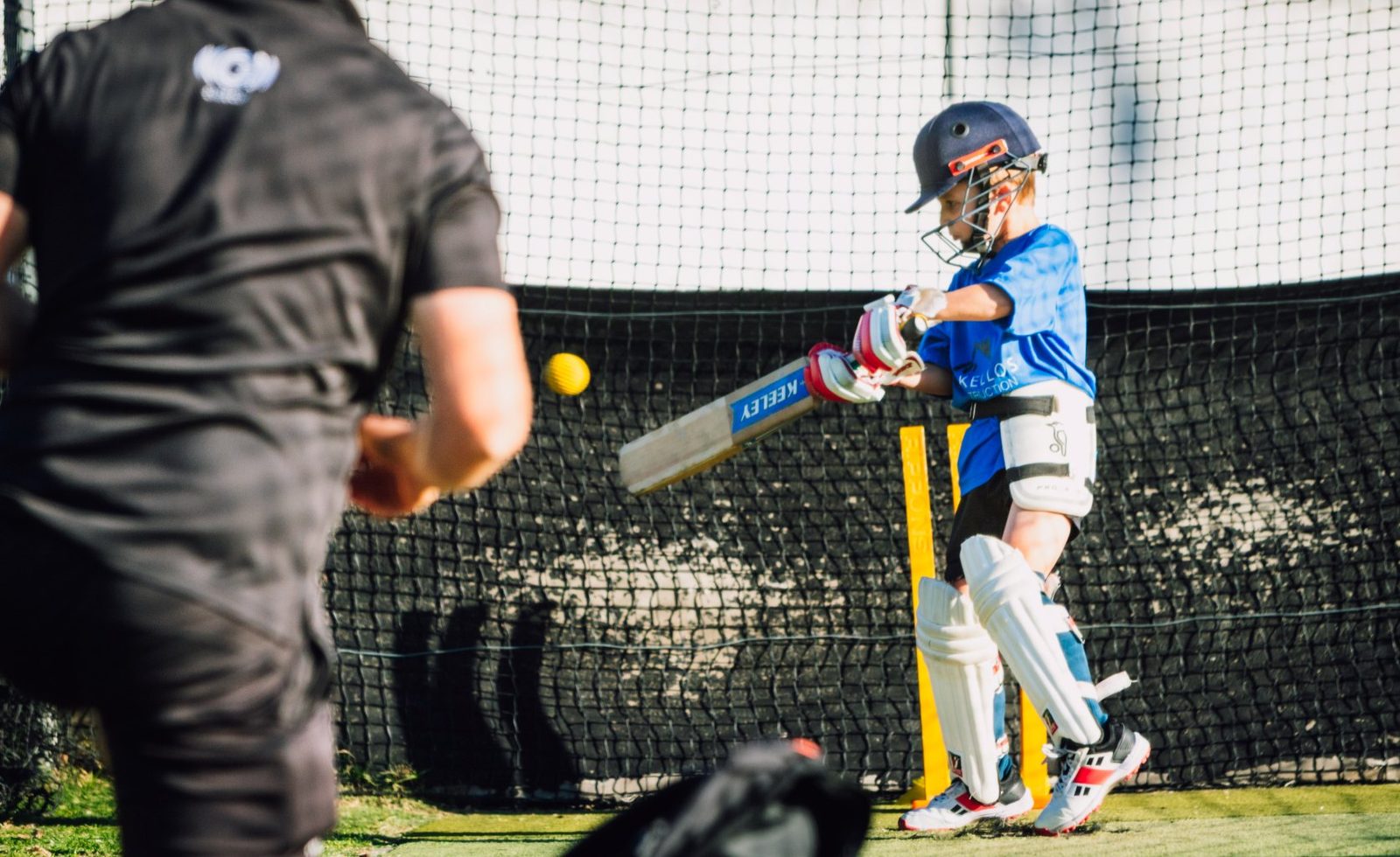 A young batsman in the nets during a coaching session